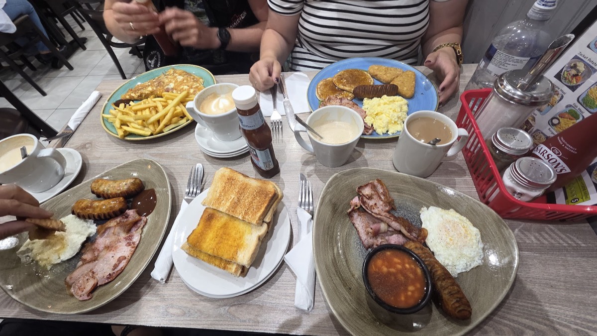 A table of full English breakfasts at Cafe Brunch — eggs, bacon, sausages, beans, toast, pancakes and coffee