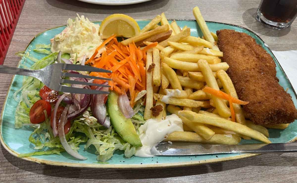 Breaded fish with chips, salad and coleslaw on a teal plate at Cafe Brunch, Wanstead
