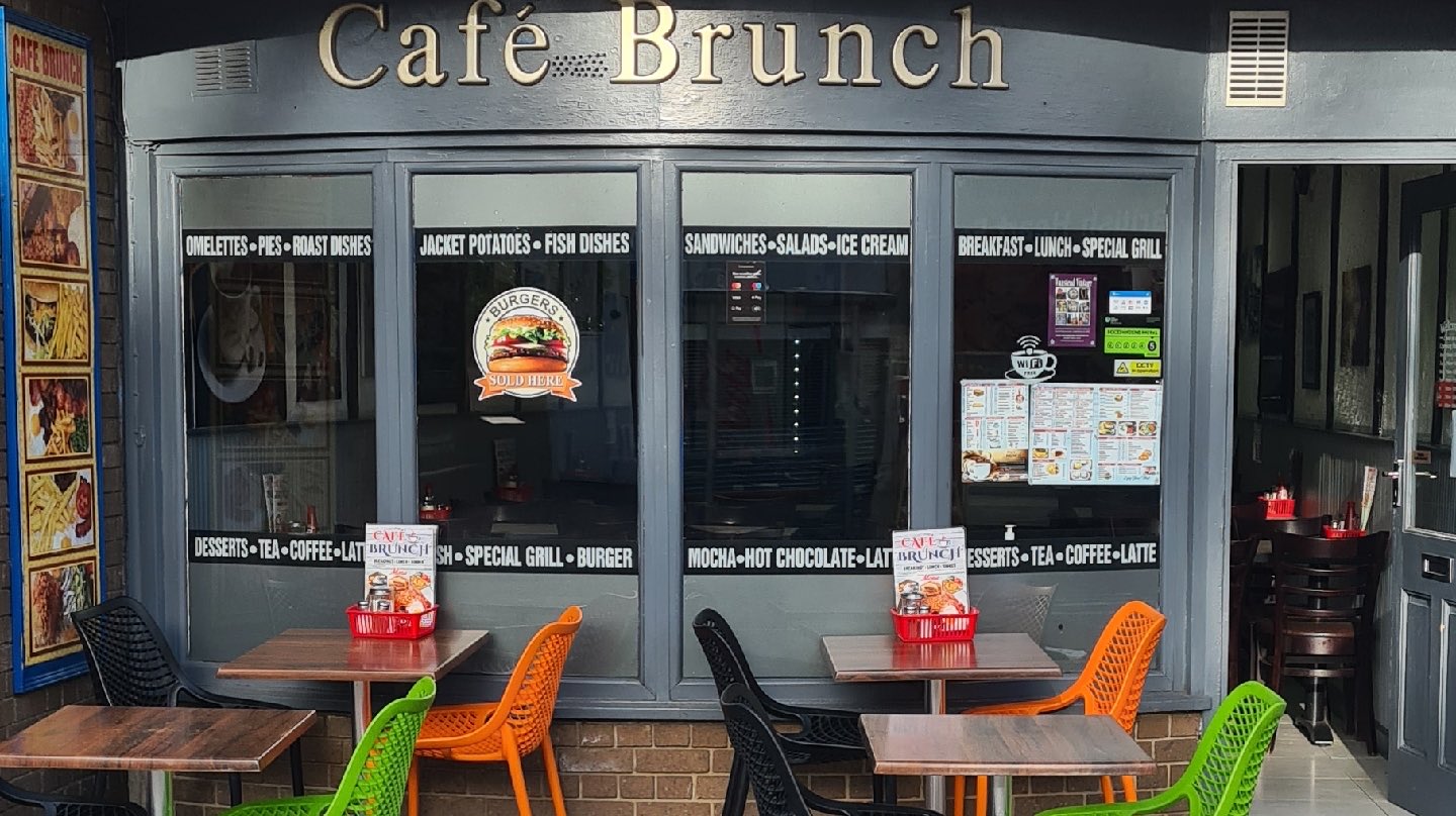 The Café Brunch shopfront on Wanstead High Street — gold lettering on a slate-grey front with pavement tables and colourful chairs